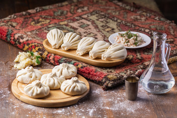 Georgian dumplings Khinkali with potato and mushroom, Vegan food, Georgian Chacha (vodka) on a wooden background
