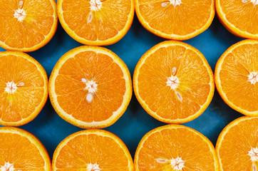 top view of juicy fruit halves orange located on a blue background