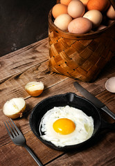 fresh organic village eggs on wooden table, healthy food,  village food. black pan with fried egg. small bench background