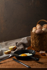 fresh organic village eggs on wooden table, healthy food,  village food. black pan with fried egg. small bench background
