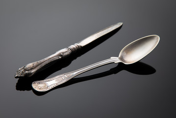 
Old spoon and knife on a gray gradient background