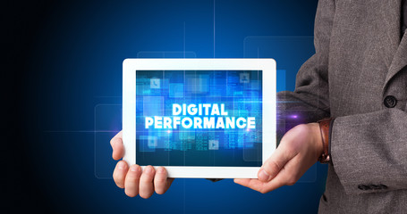 Young business person working on tablet and shows the inscription: DIGITAL PERFORMANCE