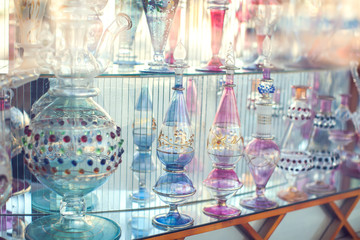 A lot of beautiful empty arabic style glass bottles for perfume in the shop behind the glass