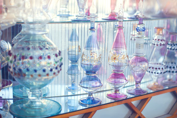 A lot of beautiful empty arabic style glass bottles for perfume in the shop behind the glass