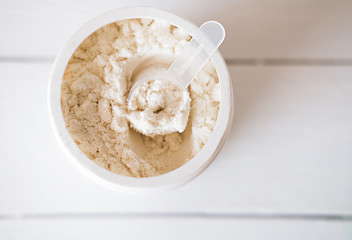 scoop of fish collagen. collagen peptides in container or jar. Copy space for text. Healthcare supplement concept. close up view on wooden background.