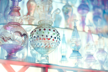 A lot of beautiful empty arabic style glass bottles for perfume in the shop behind the glass