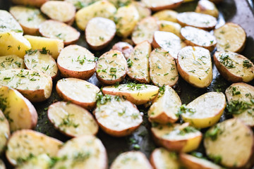 delisious potato halves, oven roasted, with fennel, a in a baking tray, home made simple natural food. stay home and cook concept. country style food. close up view.