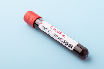Fototapeta premium New coronavirus cases in the country. Blood test tube with positive result on coronavirus on blue table in the laboratory