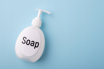 Big white bottle of liquid soap on blue background