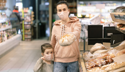 A young woman shopping in a supermarket during a virus epidemic.