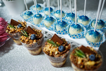 Beautifully decorated sweet buffet table on which cakes, muffins, marshmallows, pecans. Dessert table for a party, goodies for the wedding. Close up. Candy bar. A buffet for a wedding