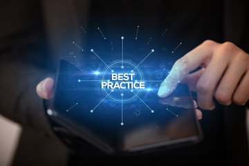 Naklejka premium Businessman holding a foldable smartphone with BEST PRACTICE inscription, new business concept