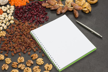 Obraz na płótnie Canvas Candied fruit, Dry fruit Nut, notebook, pen. Nutritious snack for weigh loss and immunity boosting