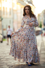 Naklejka premium beautiful girl on a field of flowers in a beautiful dress