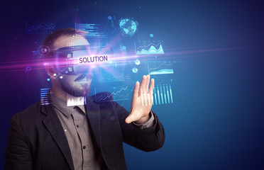 Businessman looking through Virtual Reality glasses with SOLUTION inscription, new business concept