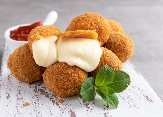 Fried breaded mozzarella cheese balls with tomato sauce close up - 335636678
