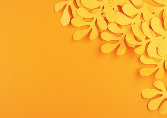 tropical yellow autumn leaves cut out of paper on a yellow background