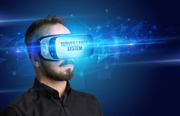 Businessman looking through Virtual Reality glasses with SURVEILLANCE SYSTEM inscription, cyber security concept
