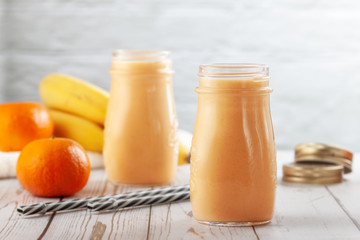 Tangerine and banana smoothie on wooden table