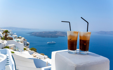 Two glasses of cold coffee in Santorini island. Traditional Greek Freddo cappuccino and sea view.