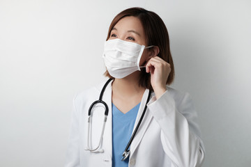 asian doctor smile under the medical mask to protect and fight infection from germ, bacteria,...