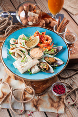 Seafood-mussels and shrimps, fish, beer snacks on the background of a wooden table.