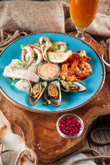 Seafood-mussels and shrimps, fish, beer snacks on the background of a wooden table.