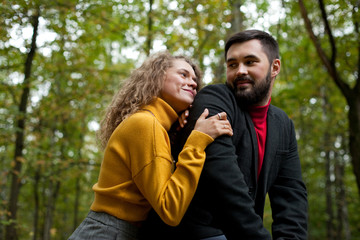 Girl hugs guy and smiles double portrait in park