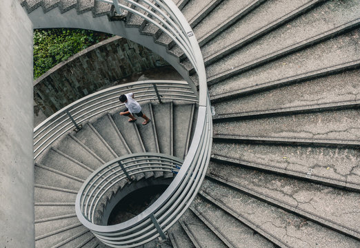 Street Photography of Man Walking Down Spiral Stairs in Hong Kong