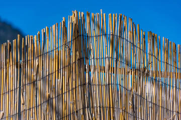 Bambuszaun vor blauem Himmel