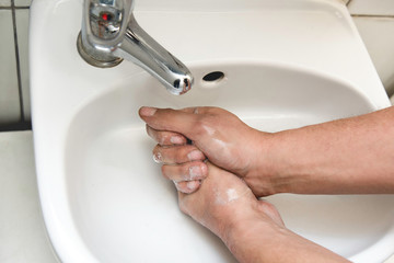 The man washes his hands thoroughly with soap and disinfectant because of the coronavirus. Coronavirus 2020
