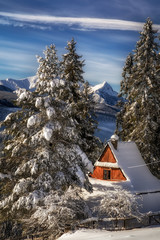 Zimowy widok na architekturę Podhala z Giewontem w tle - obrazy, fototapety, plakaty