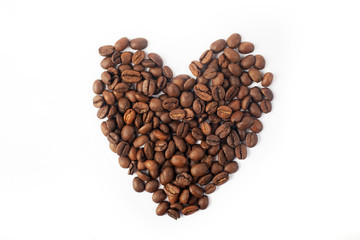 Heart laid out of coffee seeds on a white background