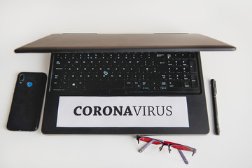 A person working remotely at home during quarantine. In the picture there is a laptop, desk, window and employee. Coronavirus 2020