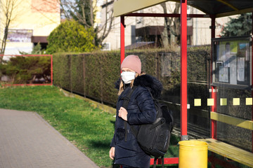 Sick woman with a hat alone on a walk in the forest, wearing protective mask against transmissible infectious diseases and as protection against the flu or coronavirus in public place. Coronavirus