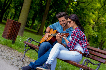 Romantic couple having fun while man playing guitar for his girlfriend