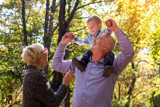 Happy grandparents and grandson spending time together in the park