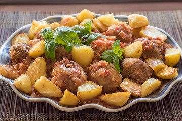 Breaded meat dumplings with tomato basil sauce and baked potatoes