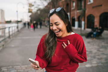 Obraz premium Woman holding phone with successful expression.