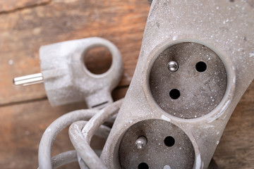 Old dirty extender on a wooden table. Electrical accessories in the workshop.