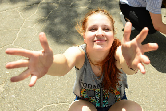 Portrait of a charming red-haired girl looking happily up and smiling joyfully