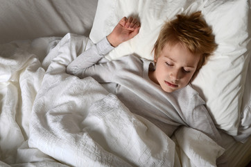 young boy sleeping in bed