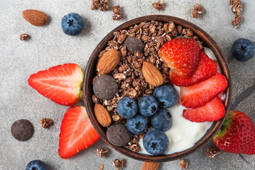 Healthy diet breakfast. bowl of oat chocolate granola with yogurt, fresh berries and almonds. top...