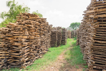 Stack of split logs for woodfiring at backyard garden of ceramic pottery in the North Vietnam