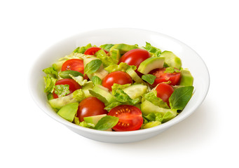 Salad with tomato, avocado, cucumber, lettuce, and basil in a white bowl isolated on white background.