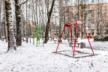 Old soviet apartment flat buildings and playground in Rivne, Ukraine in winter cold snow weather gray gloomy poverty architecture