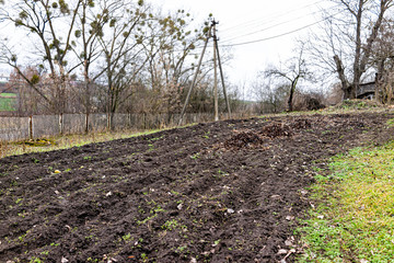 Winter garden vegetable patch dirt tilled rows in Ukraine dacha in countryside with black rich soil...