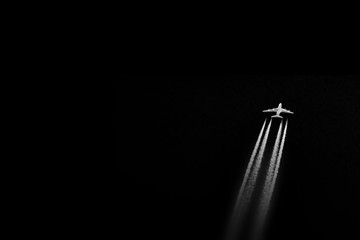 Abstraction: plane (A380) emitting contrails while cruising in a dark sky.