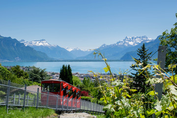Red cable car on the top of mountain with the view on Lake Geneva and Alps mountains