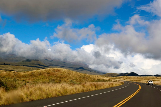 Hawaii Big Island nature background. Scenic landscape with highway 200 between Mauna Kea and Mauna Loa to Hilo. Bright blue sky with clouds over over mountain.